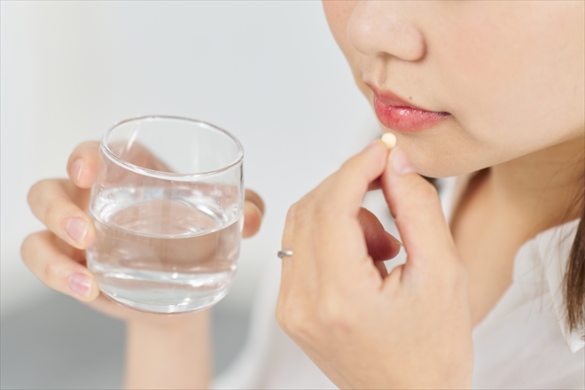 サプリメントを飲む女性