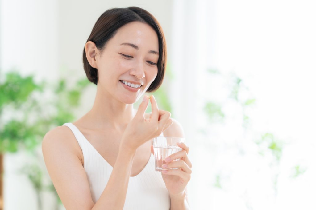 サプリメントを飲む女性