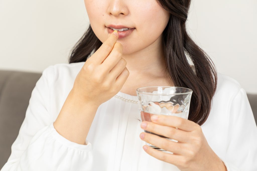 サプリを飲む女性
