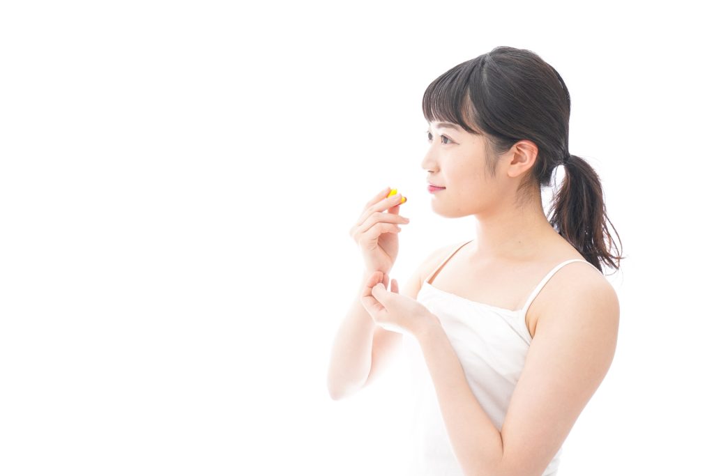 サプリメントを飲む女性