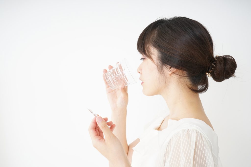 サプリメントを飲む女性