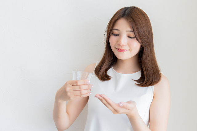 サプリメントを飲む女性