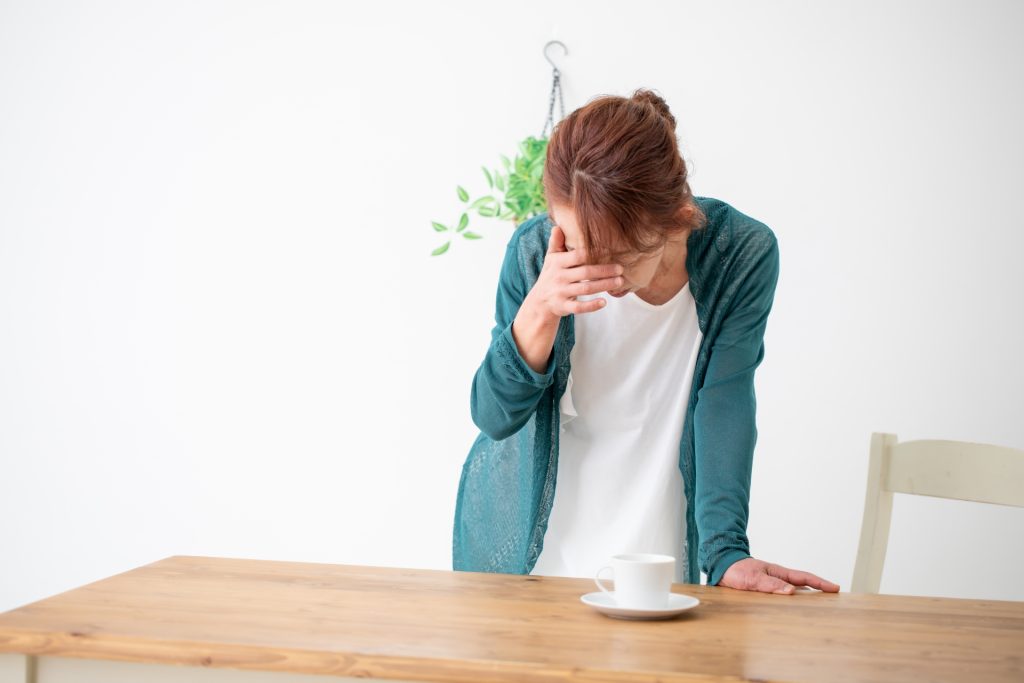 痛みで頭を押さえる女性