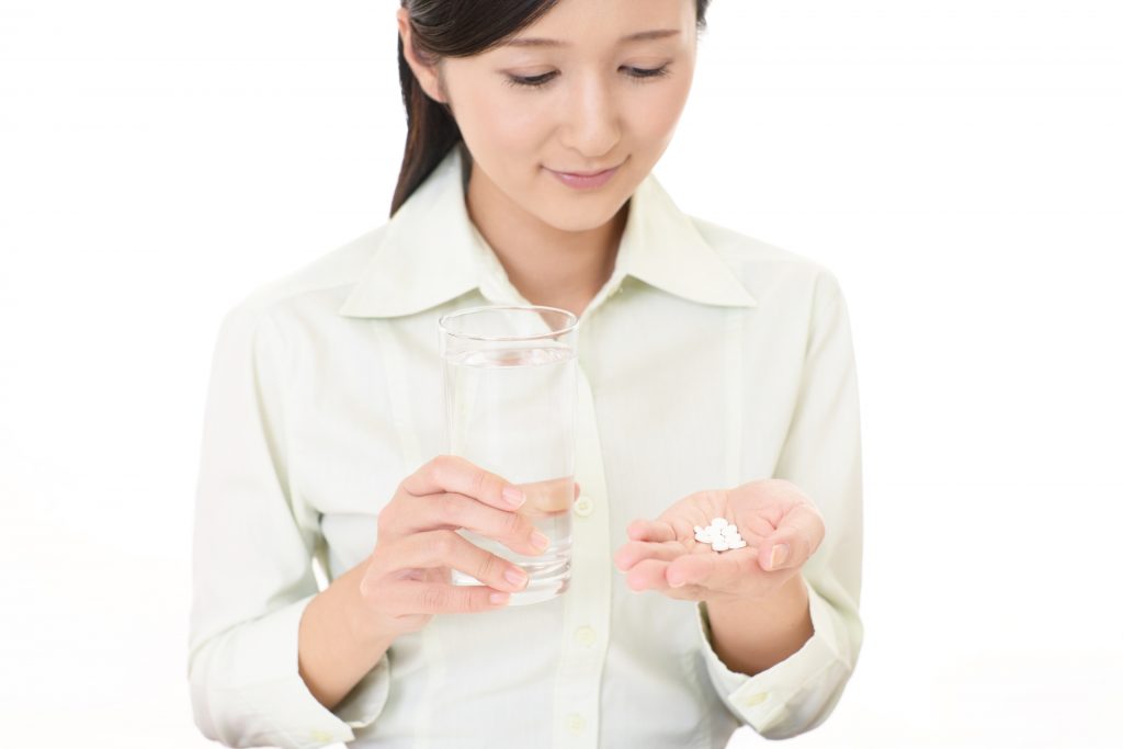 サプリメントを飲む女性