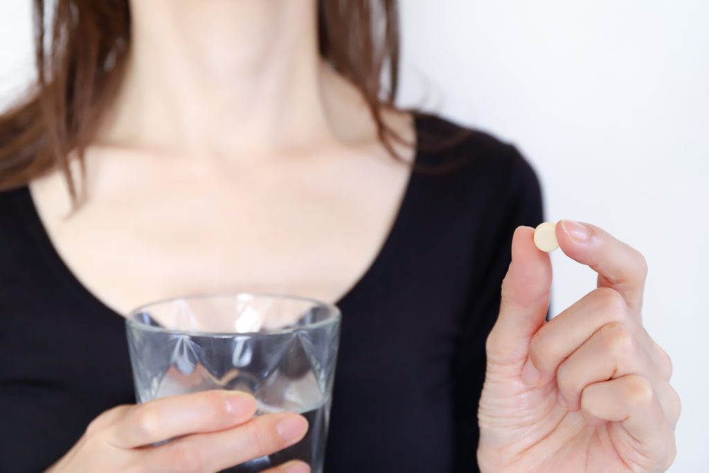 サプリメントを飲む女性
