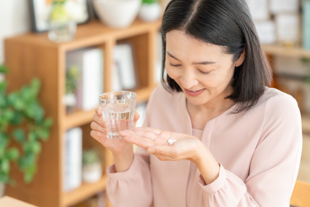 サプリメントを飲む女性