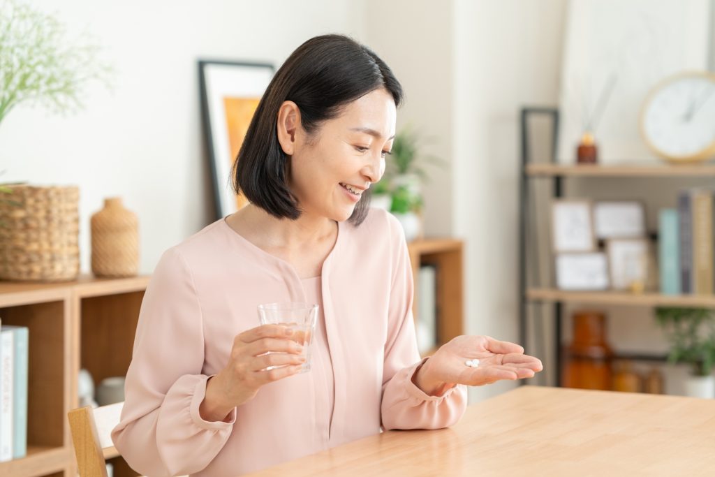 サプリを飲む女性